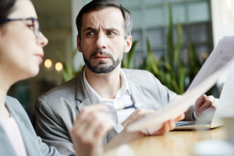 A man looks suspiciously at a woman, who appears to be giving advice